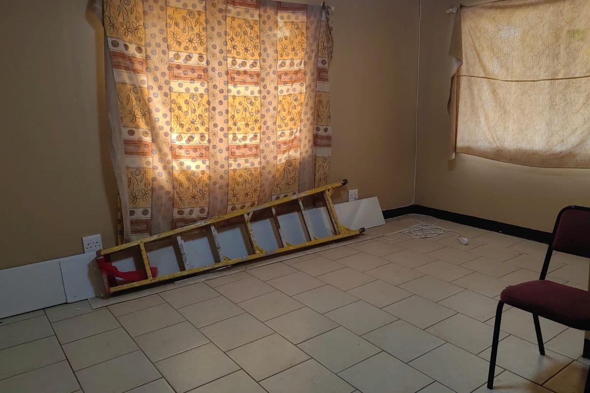 A sparsely furnished room featuring tiled flooring, neutral wall tones, and basic electrical points, suitable for a bedroom or home office space.