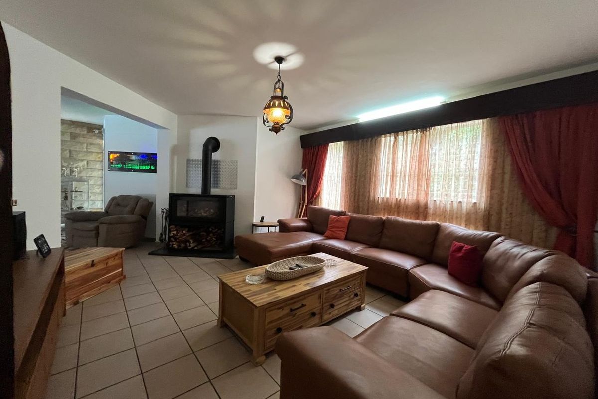 Spacious living room featuring ceramic floor tiles and a prominent freestanding fireplace, offering a comfortable and functional layout.