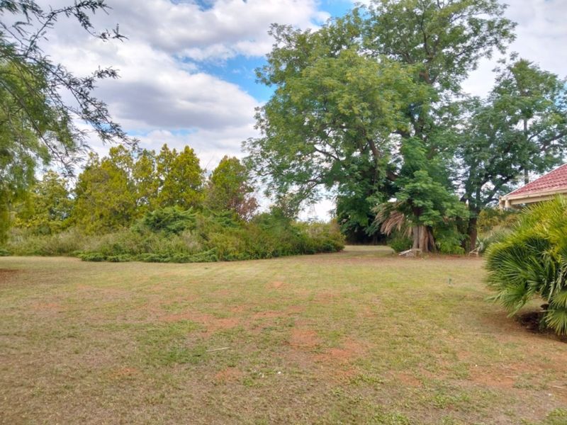 A spacious, established garden area featuring mature trees and shrubs, providing a natural and private outdoor setting on the farm property.