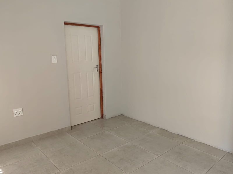 A vacant bedroom featuring neutral tiled flooring and plain walls, ready for personalization or staging.