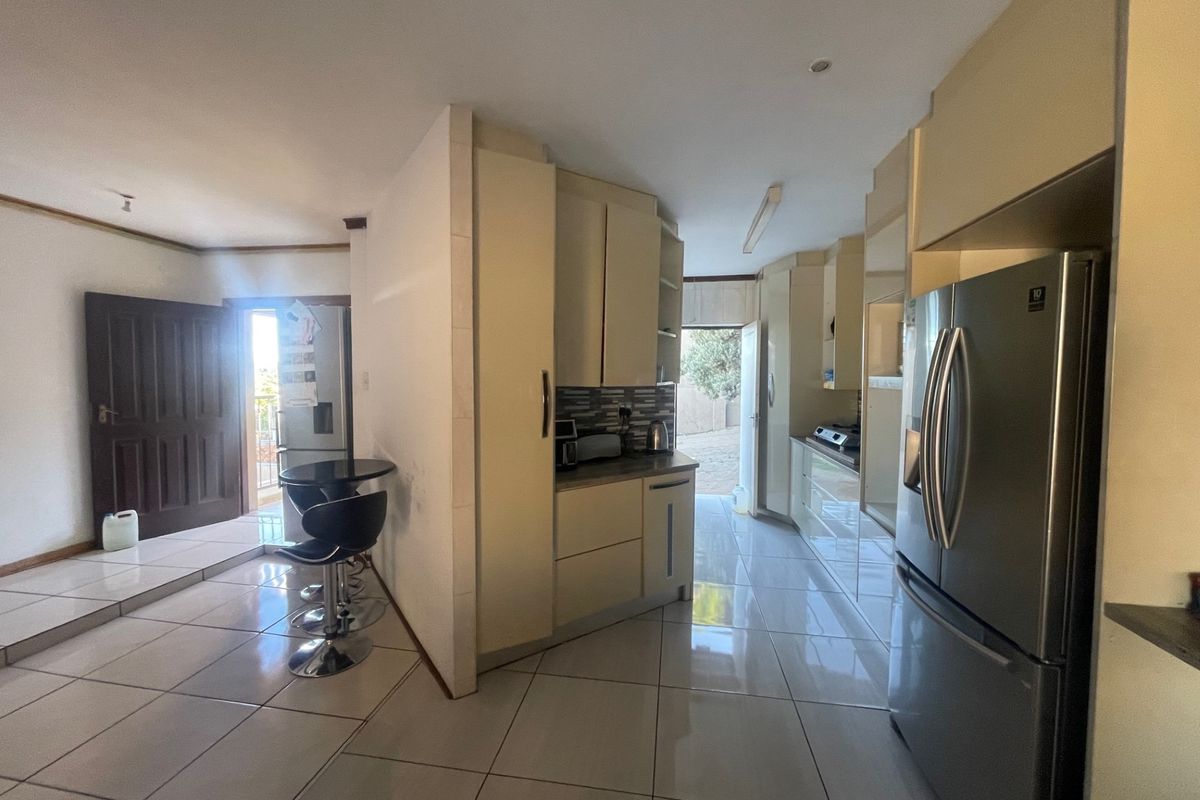A functional kitchen area featuring built-in cabinetry, tiled flooring, and integrated appliances, providing a practical layout for daily cooking and meal preparation.