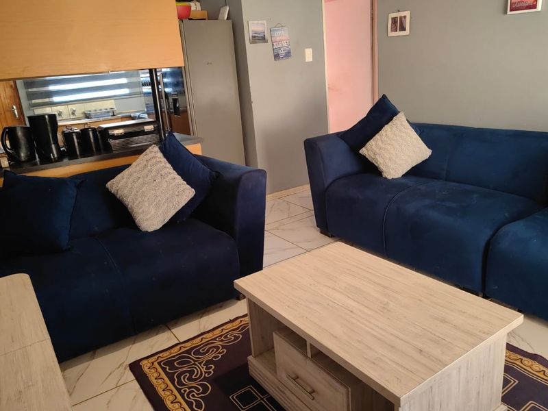 Open plan living area featuring tiled flooring and a convenient pass-through window connecting to the kitchen space.