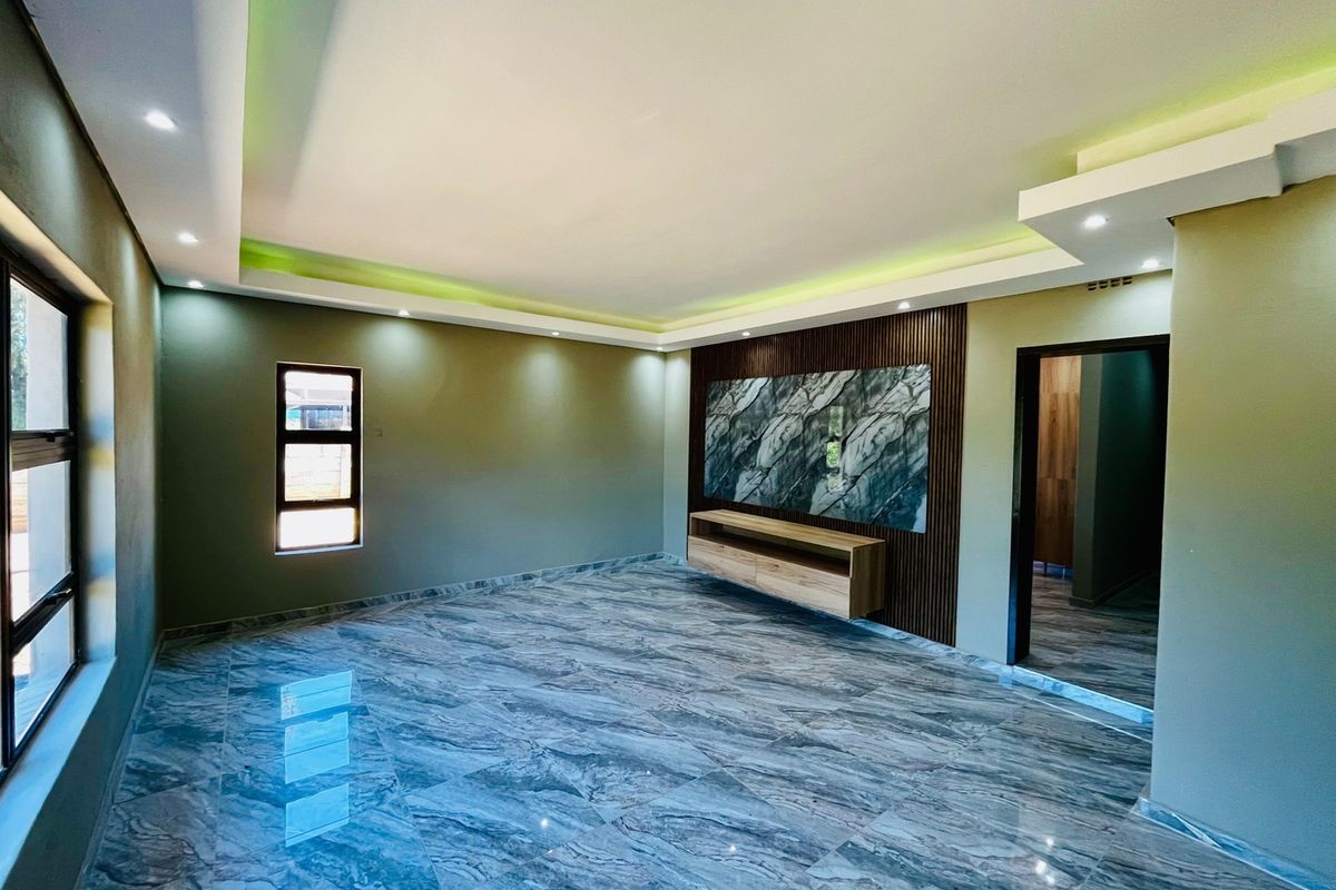 Modern living room featuring polished marble-effect floor tiles, recessed cove lighting, and a custom built-in media unit with slatted wood and marble accents.