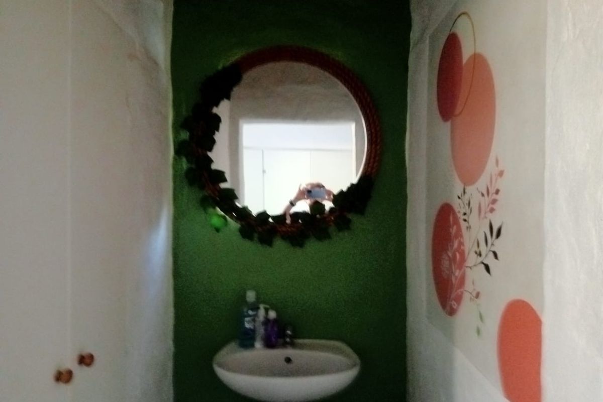 A small bathroom or powder room featuring a wall-mounted basin and built-in storage cabinetry.