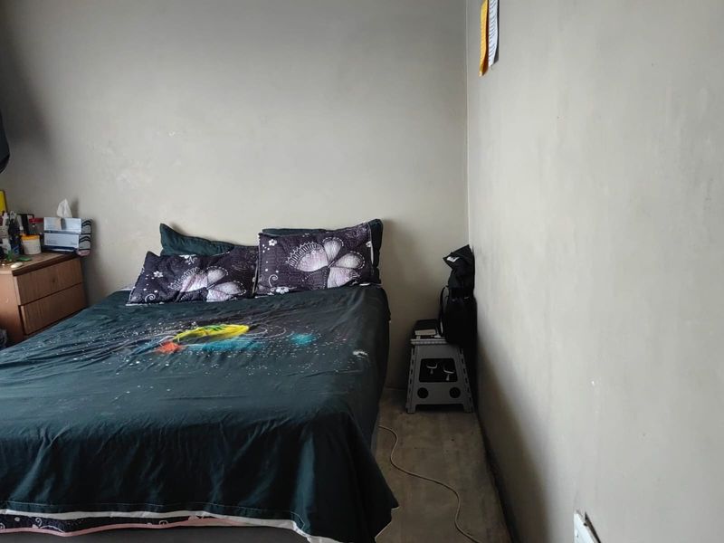 A simple bedroom featuring plain walls and basic flooring, offering a blank canvas for potential interior updates and personalization.