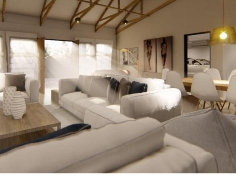 Spacious open-plan living and dining area featuring high vaulted ceilings with exposed timber trusses and modern pendant lighting.