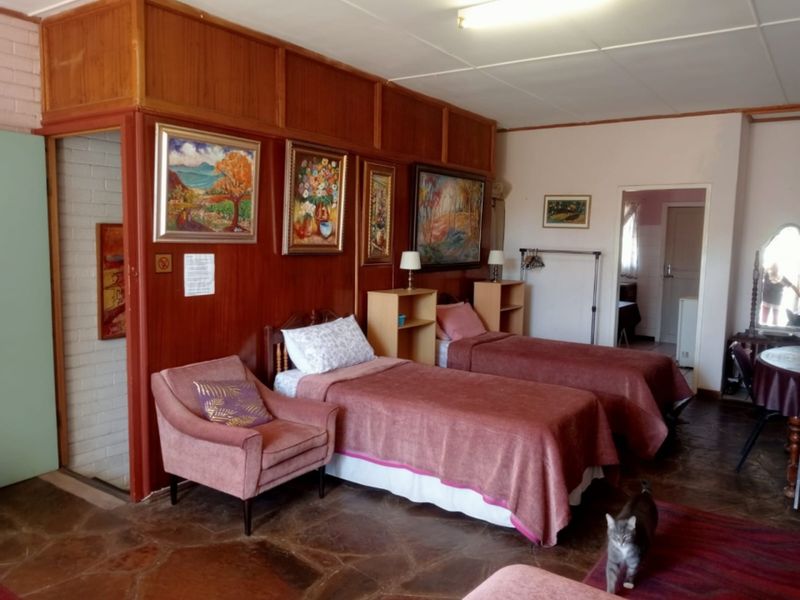 A bedroom featuring wood-paneled walls and stone tile flooring, offering a traditional aesthetic with potential for modern updates.