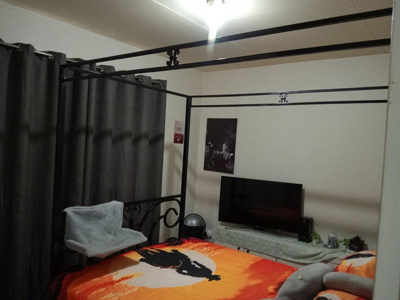 A standard bedroom featuring neutral walls and basic window treatments.