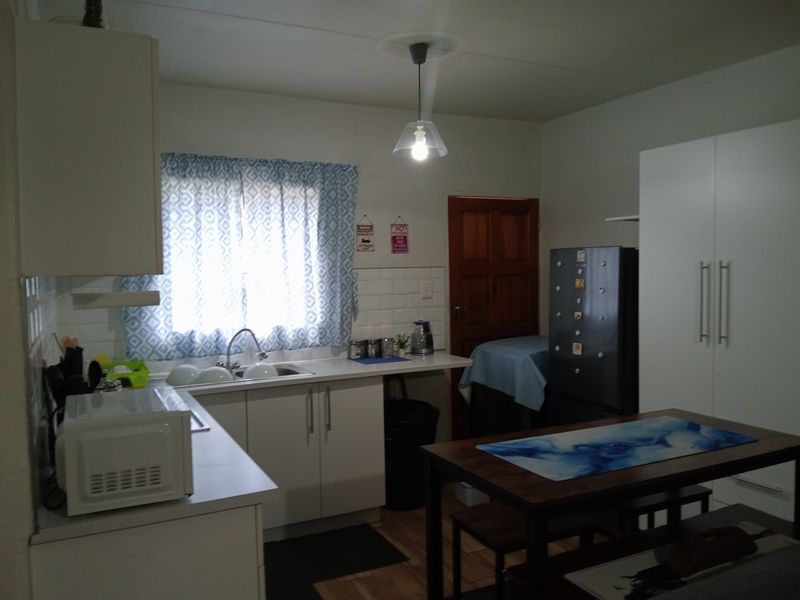 A functional kitchen featuring white cabinetry, a subway tile backsplash, and a stainless steel sink, providing a clean and practical workspace.