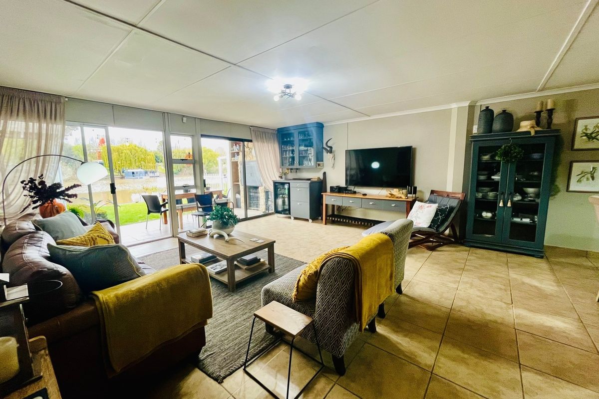Spacious living room featuring tiled flooring, built-in cabinetry, and large sliding glass doors providing natural light and access to the outdoor patio area.