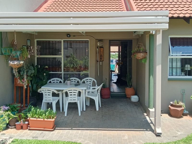 A covered patio area with paved flooring, providing a functional outdoor space for relaxation and access to the main dwelling.