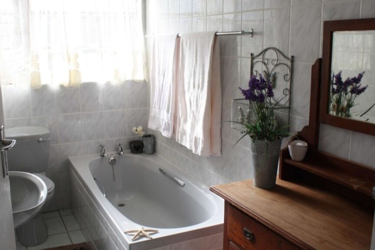 A functional bathroom featuring a standard bathtub, toilet, and wall tiling, offering a clean and practical space.