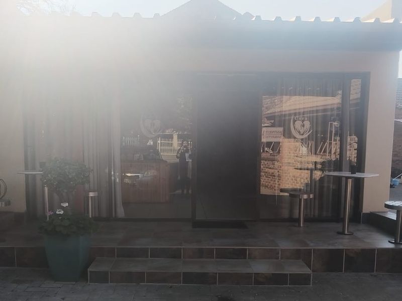 A covered patio area featuring tiled flooring and sliding glass doors providing access to the interior of the guest house.
