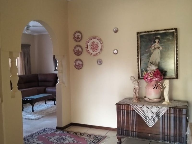A living area featuring a distinctive arched doorway leading to an adjacent space, finished with neutral wall tones and tiled flooring.