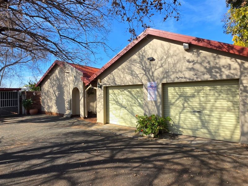 Front exterior view of the property featuring a double garage, paved driveway, and tiled roof structure.