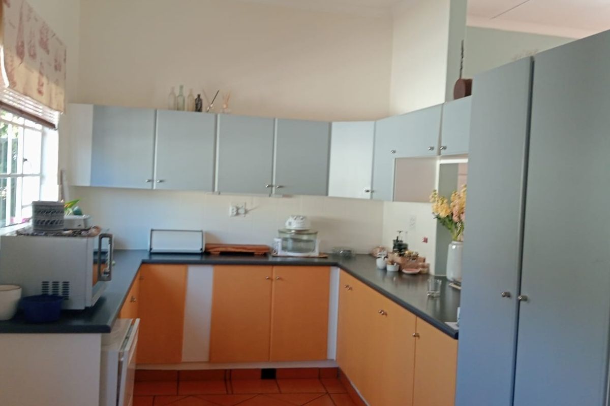 A functional kitchen featuring U-shaped cabinetry, laminate countertops, and tiled flooring, offering a practical layout with ample storage space.