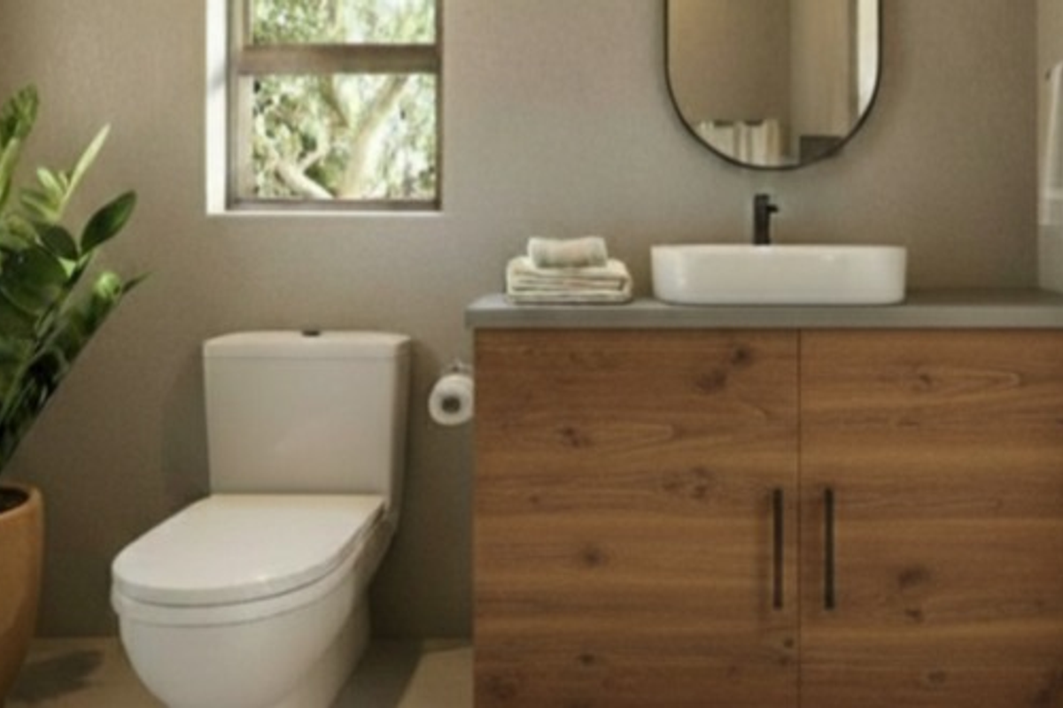 Modern bathroom featuring a wood-finish vanity cabinet, vessel sink, and contemporary toilet in a well-lit space.