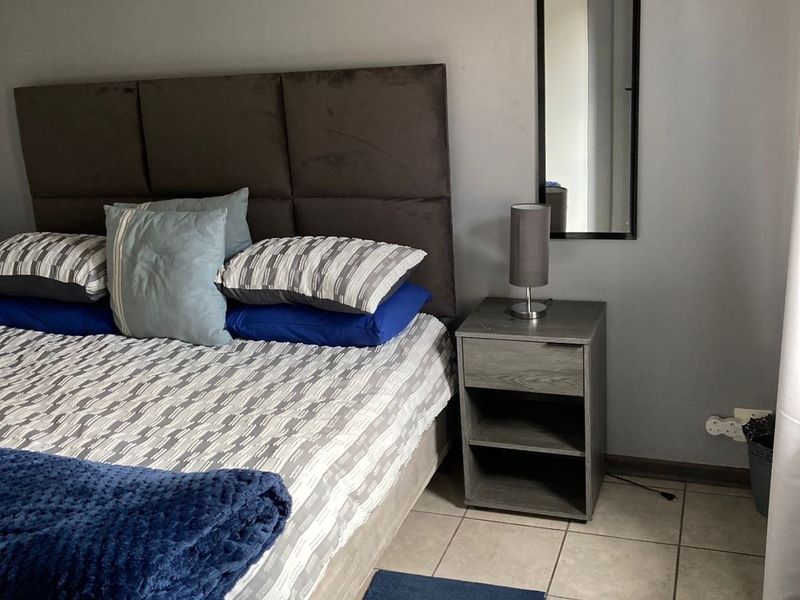 A bedroom featuring neutral wall paint and tiled flooring, providing a functional and comfortable sleeping space.