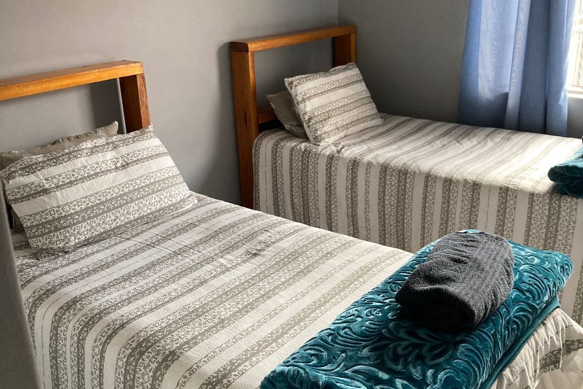A functional bedroom featuring neutral wall tones and tiled flooring, providing a comfortable space for rest.