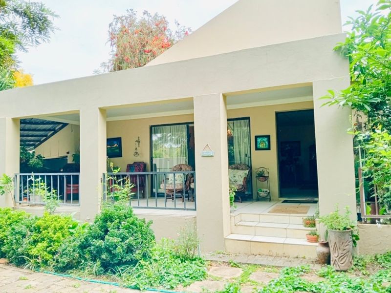 A covered patio area featuring tiled flooring, metal railings, and sliding glass door access to the main interior living space.
