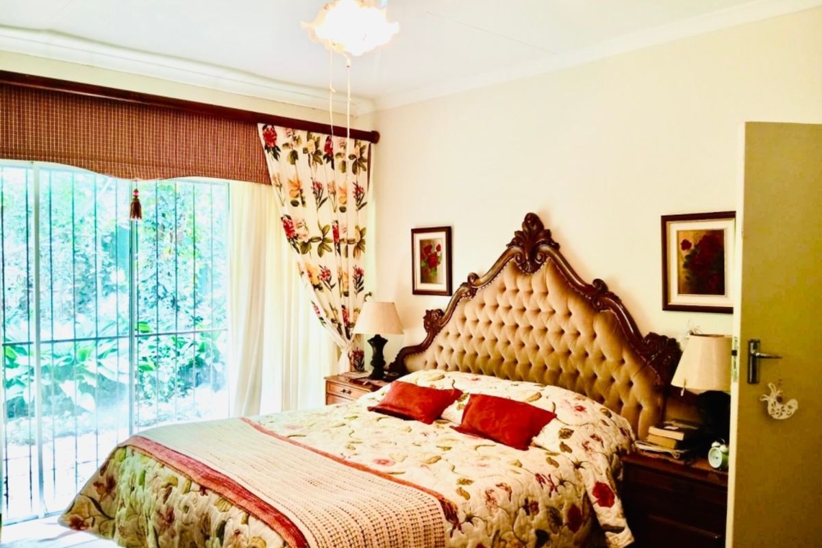 A bedroom featuring a ceiling fan and a sliding glass door with security bars, providing access to the exterior.