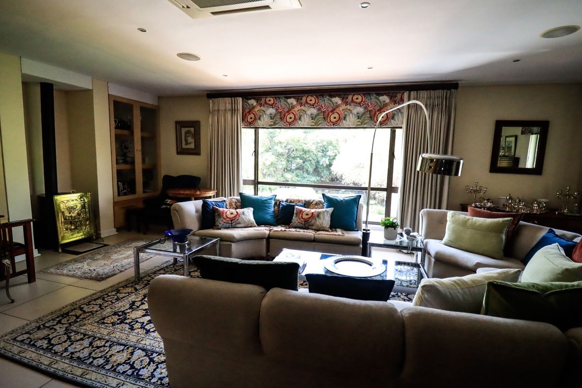 Spacious living room featuring a built-in fireplace, recessed lighting, and large windows that provide ample natural light and garden views.