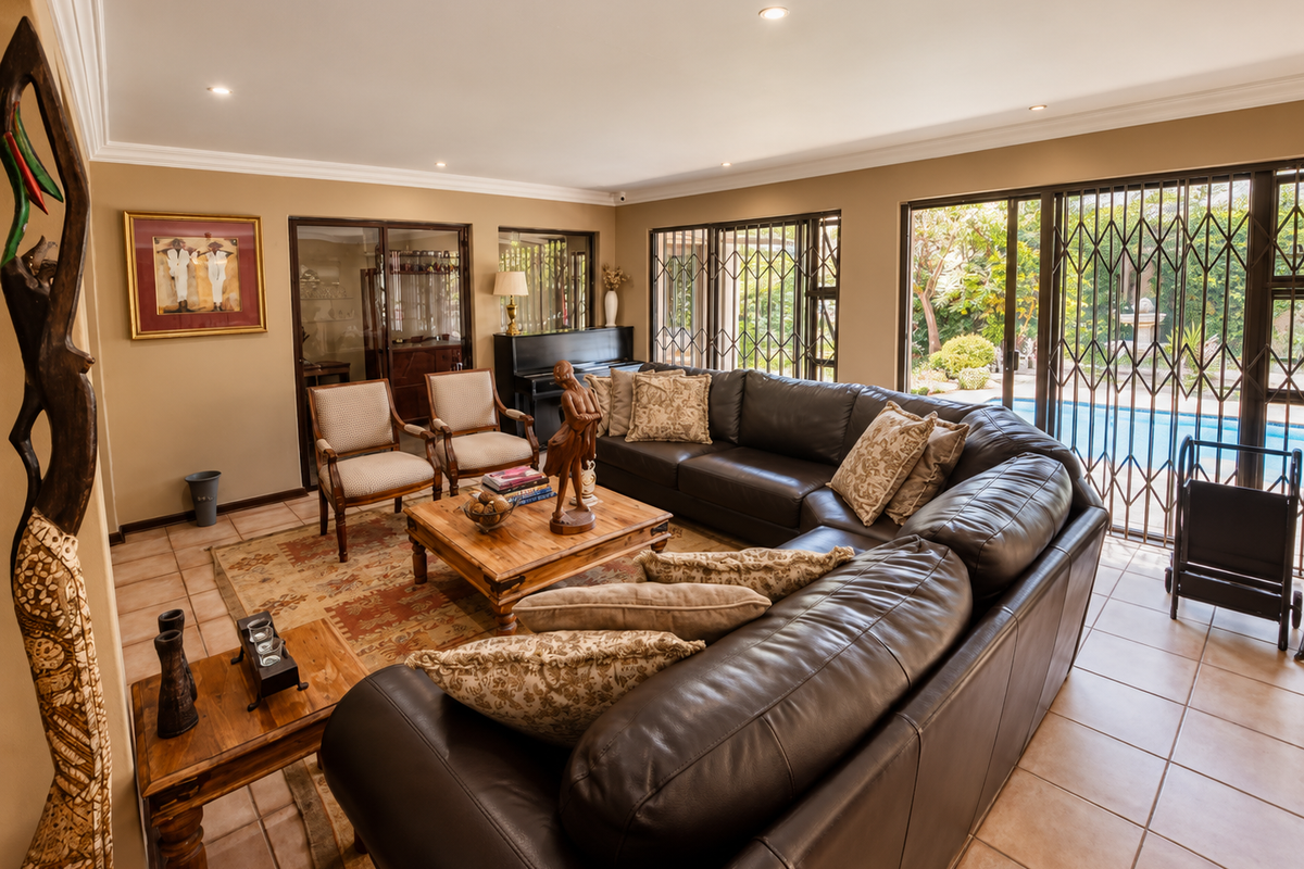 Spacious living room featuring tiled flooring, recessed lighting, and large sliding glass doors that provide direct access to the outdoor pool area.