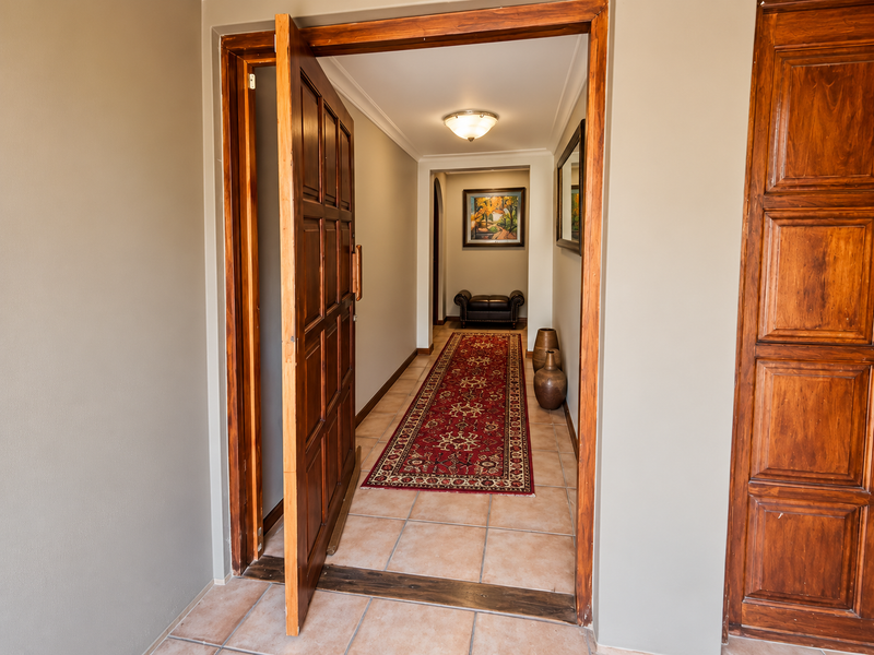 A welcoming entrance hall featuring tiled flooring, a solid wood door, and classic architectural details leading into the home's interior.