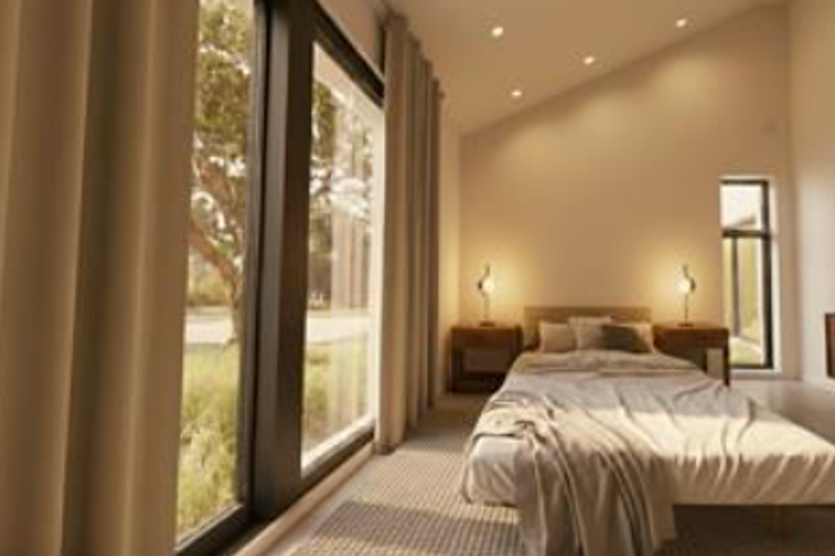 A bright and modern bedroom featuring a sloped ceiling, recessed lighting, and large floor-to-ceiling windows that provide ample natural light.
