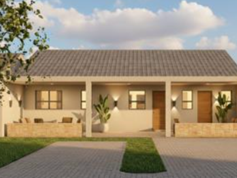 A modern townhouse exterior featuring a tiled roof, covered patio area with stone cladding, and a paved driveway.