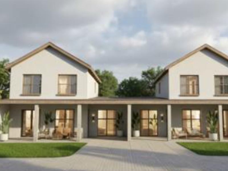 A modern double-story townhouse facade featuring a covered patio, paved driveway, and symmetrical architectural design.