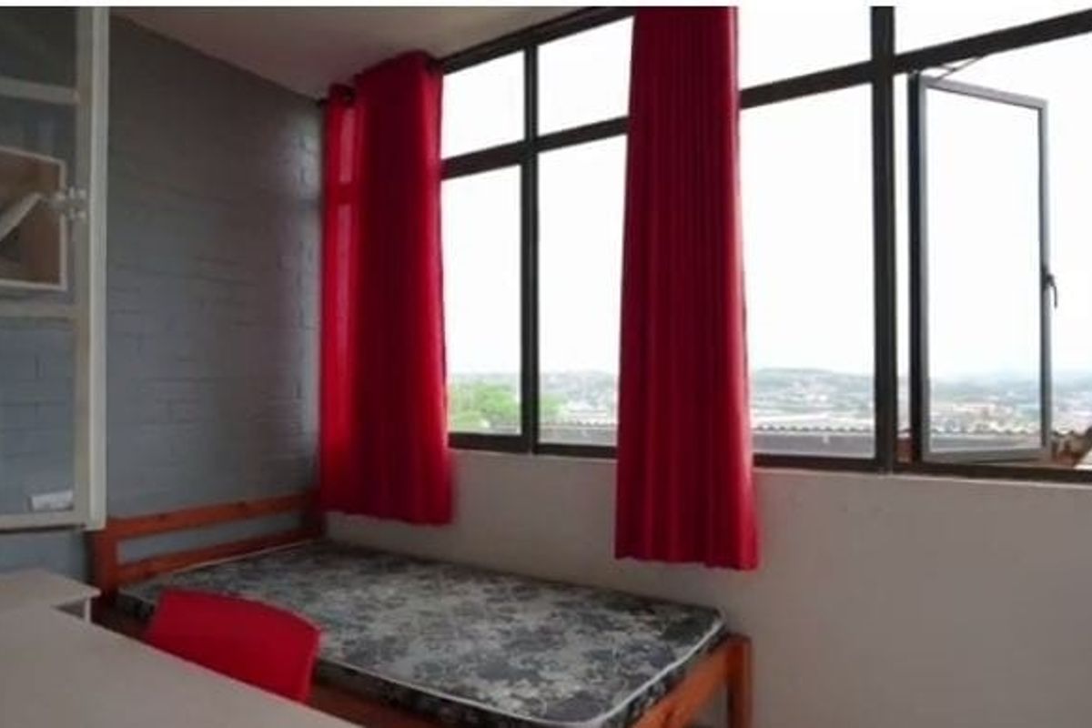 A bedroom featuring large aluminium-framed windows that provide ample natural light and expansive views.