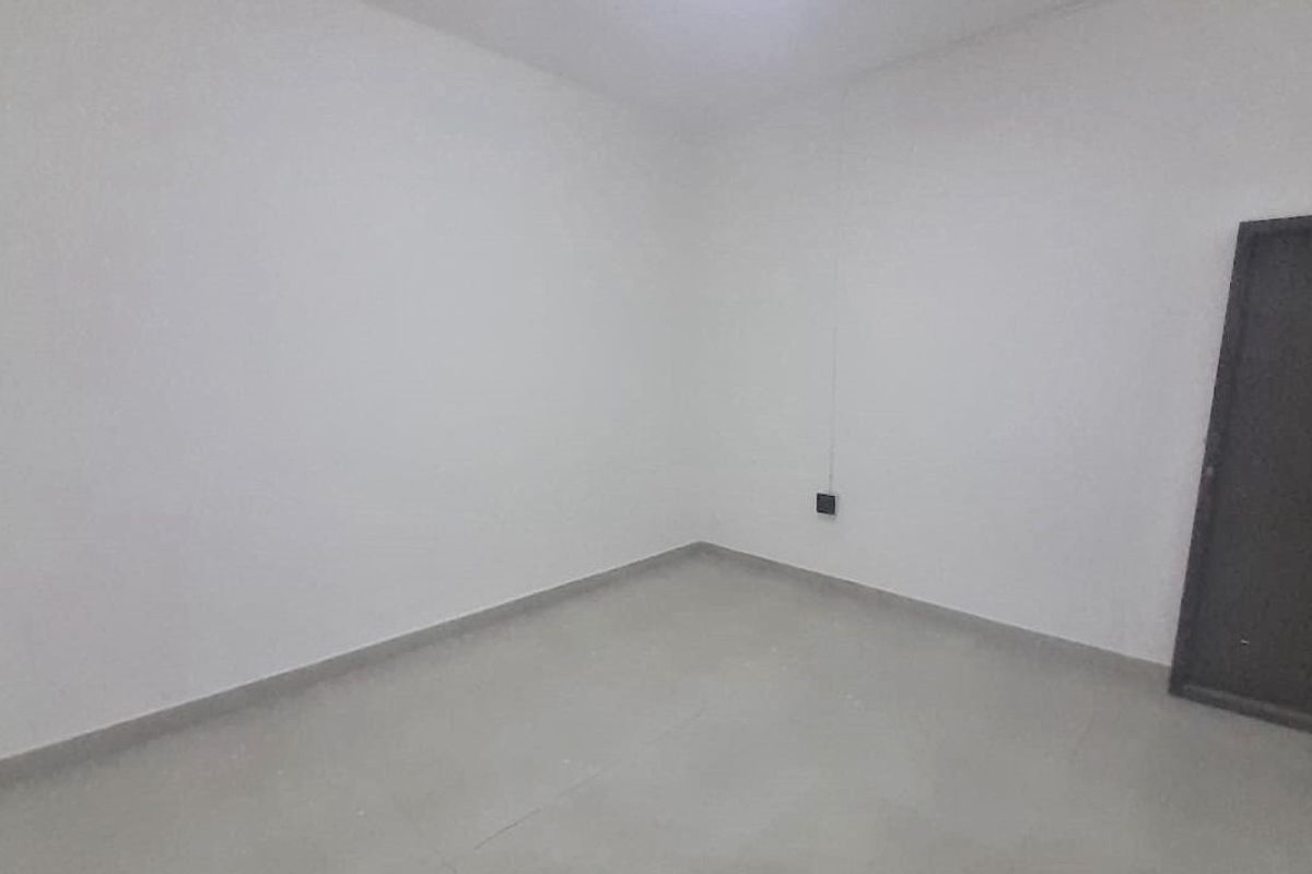 A simple, empty bedroom featuring neutral tiled flooring and white walls, providing a blank canvas for personalization.