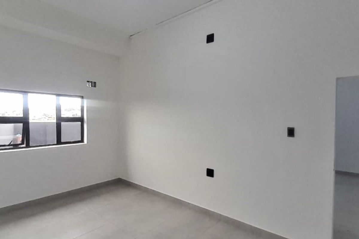 A bright, empty living area featuring neutral tiled flooring and clean white walls, ready for personalization.