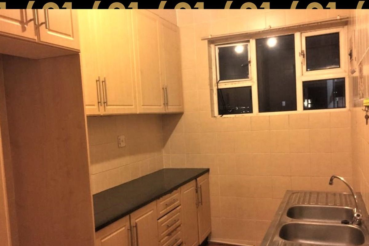A functional kitchen featuring built-in cabinetry, a double bowl sink, and tiled splashbacks, offering a clean and practical layout for daily use.