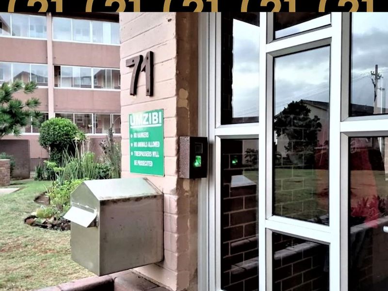 Entrance area of the apartment building featuring a secure intercom system, external mailbox, and glass panel door access.