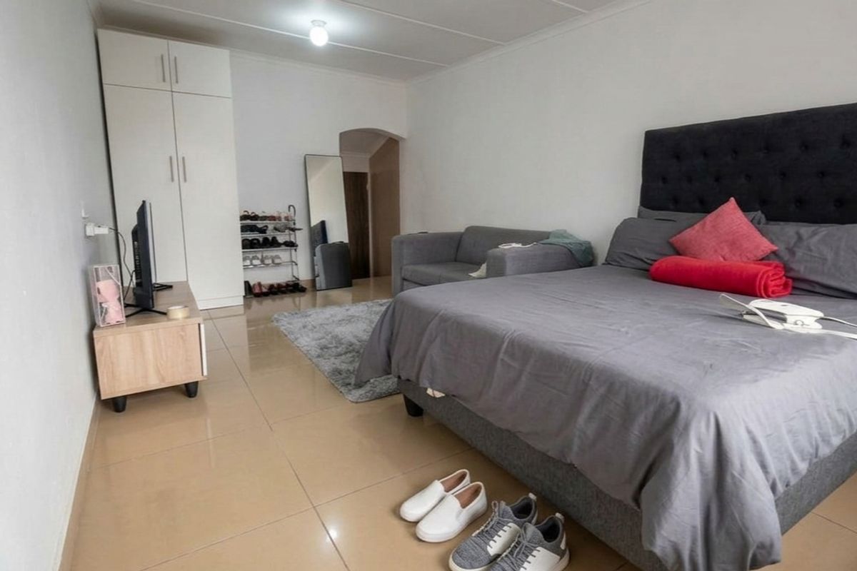 A bedroom featuring tiled flooring and a built-in wardrobe, offering a functional living space.