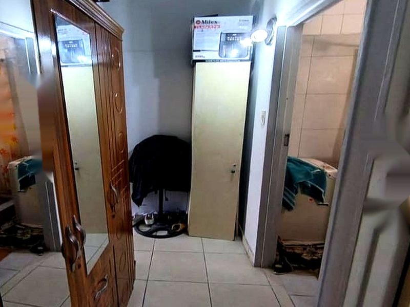 A narrow hallway area with tiled flooring providing access to adjacent rooms.
