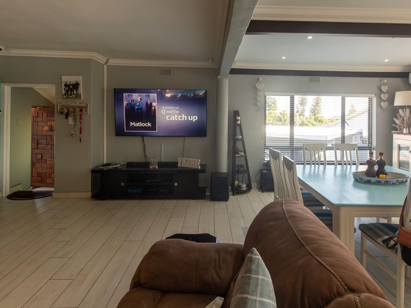 Spacious open-plan living and dining area featuring tiled flooring, recessed lighting, and an integrated air conditioning unit, creating a bright and functional living space.