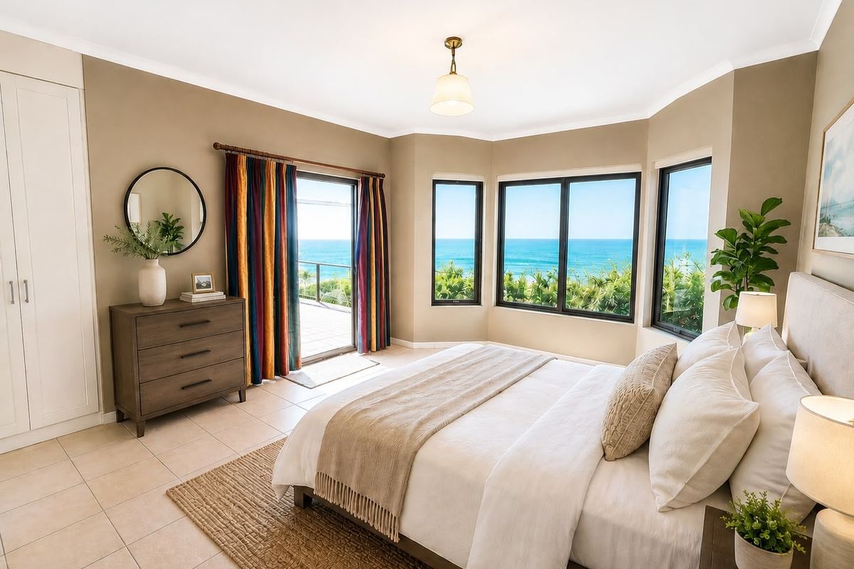 Spacious bedroom featuring tiled floors, built-in wardrobes, and large bay windows offering expansive ocean views with direct access to a private balcony.