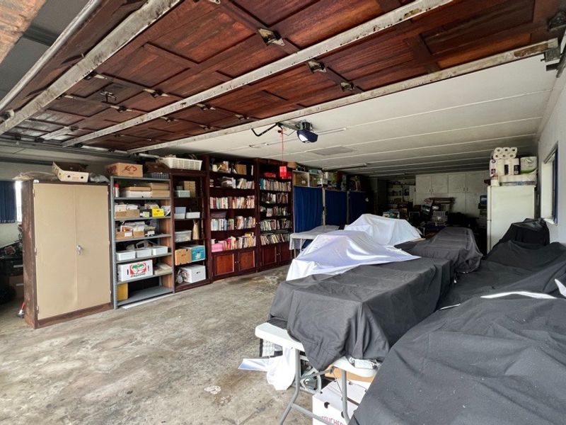 Spacious garage featuring a sectional door, built-in storage cabinetry, and concrete flooring, offering ample space for vehicle parking and workshop use.