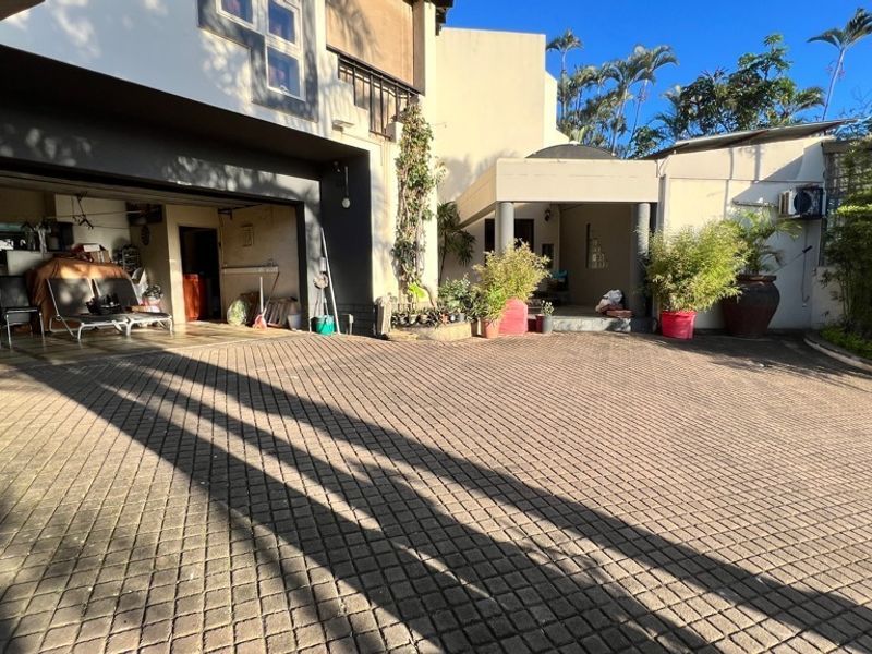 A paved driveway leading to a double garage and a covered entrance area of the property.