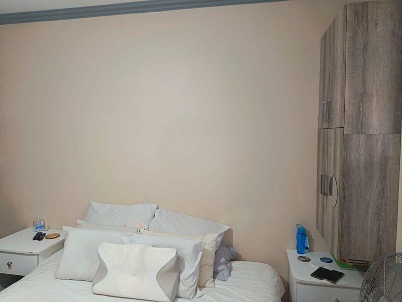 A bedroom featuring a built-in wooden cupboard and crown molding detail.
