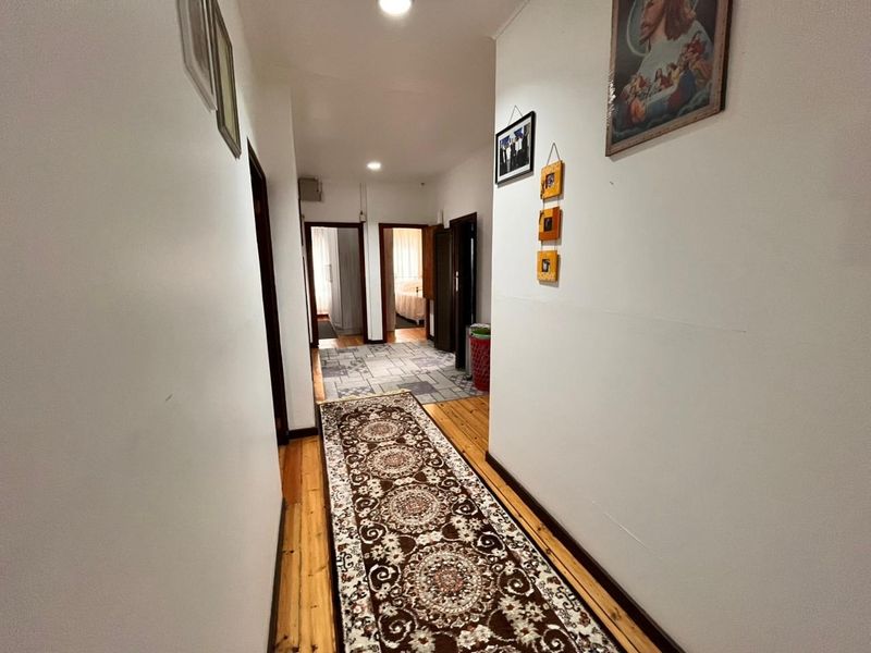A functional hallway featuring a mix of timber and tiled flooring, connecting multiple rooms within the home.