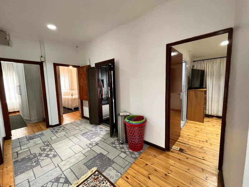 A functional hallway featuring polished timber flooring and multiple access points to adjoining rooms, providing a central circulation space within the home.