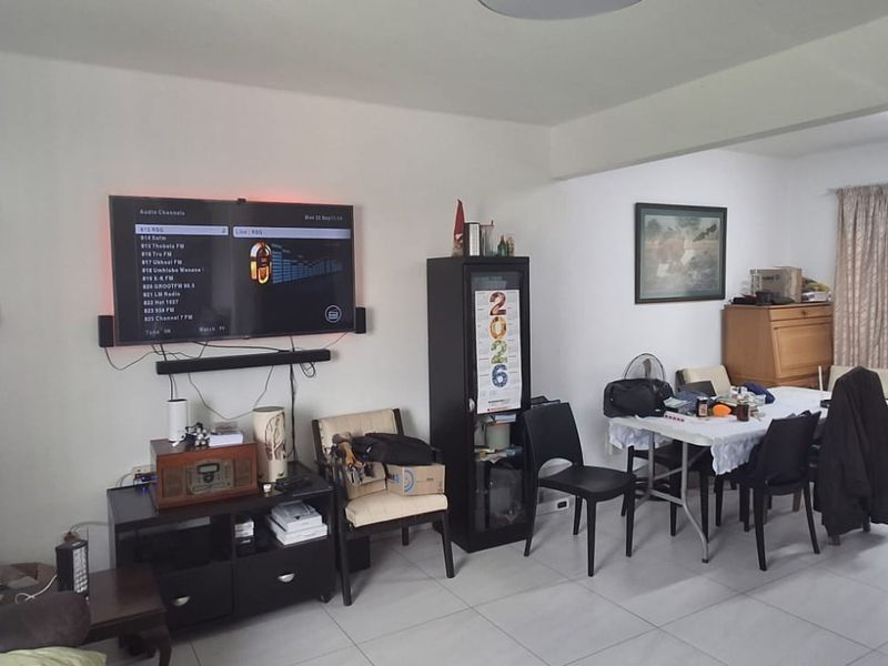 An open-plan living and dining area featuring tiled flooring and neutral wall finishes, providing a functional space for daily living.