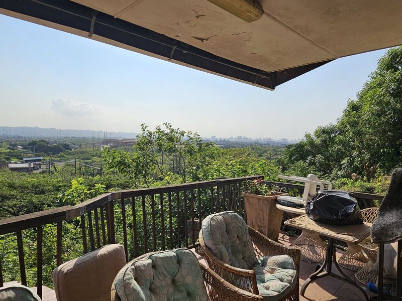 Covered balcony featuring a metal railing and expansive elevated views, requiring maintenance to the ceiling finish and railing structure.
