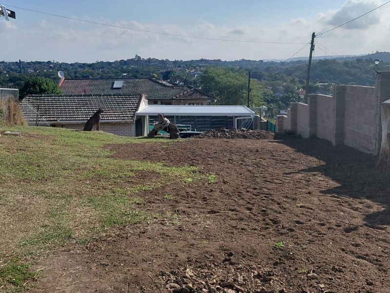 A rear yard area featuring a boundary wall and an elevated view of the surrounding neighbourhood.