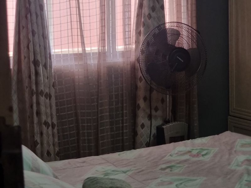 A bedroom interior featuring a window with curtains, providing natural light to the space.