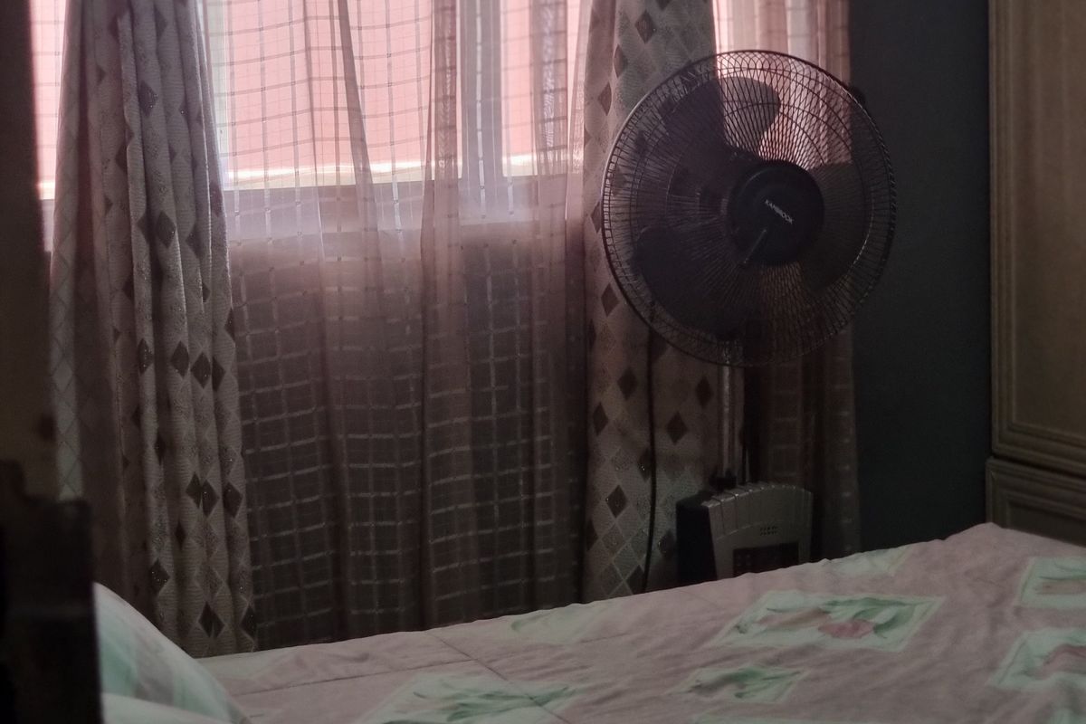 A bedroom interior featuring a window with curtains, providing natural light to the space.